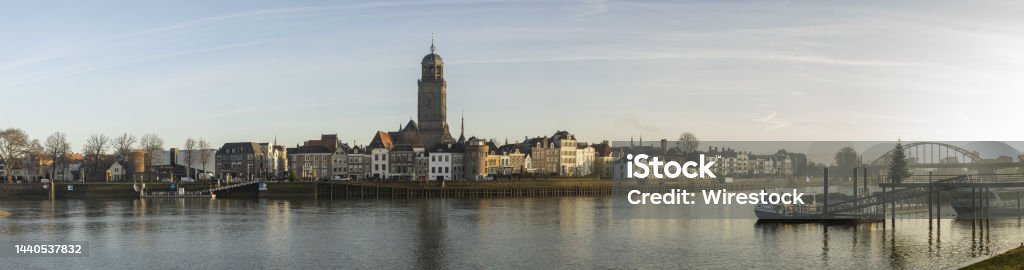 Deventer city at sunrise with river IJssel in front Super wide cityscape panorama of the Dutch Hanseatic medieval city of Deventer in The Netherlands seen from the other side of the river IJssel Architecture Stock Photo