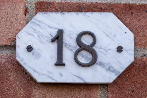 istock Marble plate with number 18 on a red concrete wall 1440537891