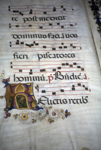 Closeup of an illuminated medieval manuscript on a  parchment with the historical Gregorian chant A closeup of an illuminated medieval manuscript on a  parchment with the historical Gregorian chant chanting stock pictures, royalty-free photos & images