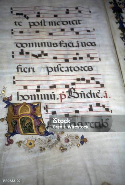 Closeup Of An Illuminated Medieval Manuscript On A Parchment With The Historical Gregorian Chant Stock Photo - Download Image Now
