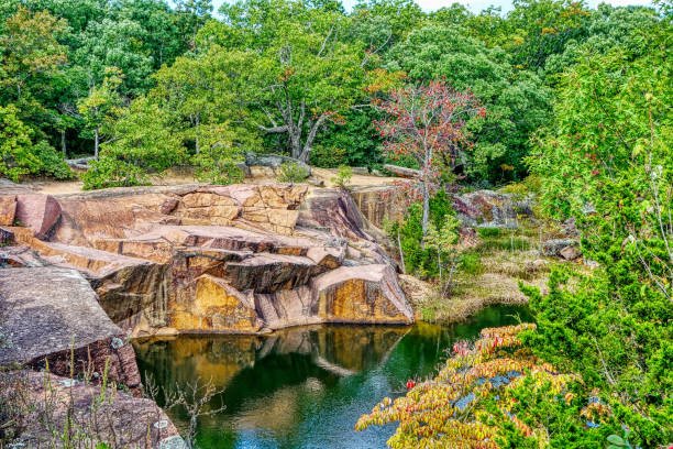 istock Pond surrounded by rocks and greenery under the sunlight - perfect for wallpapers 1440538874