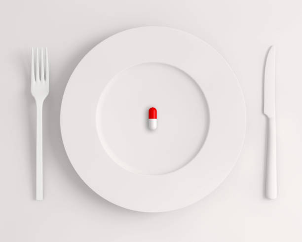 istock Top view a white plate with a pill fork and knife on a white background 1440539612