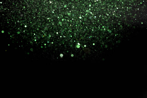 istock Beautiful, sparkling green glitter pouring down from above on a dark background 1440539653