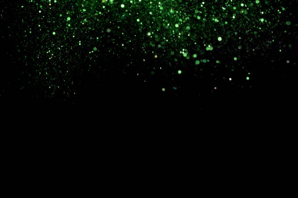 istock Beautiful, sparkling green glitter pouring down from above on a dark background 1440539737