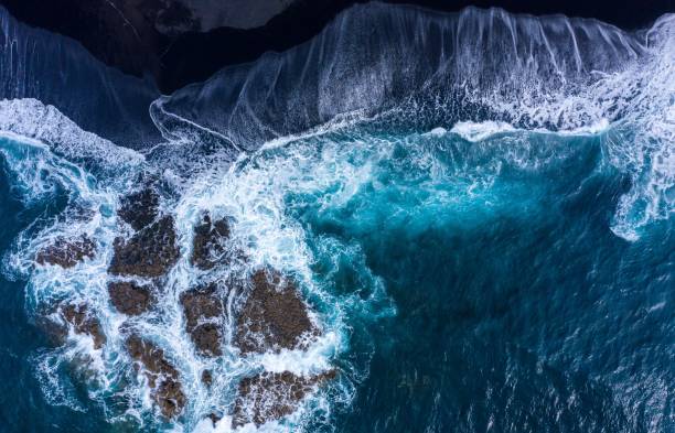 istock the turquoise ocean breaks in white foamy waves on the black beach 1440540288