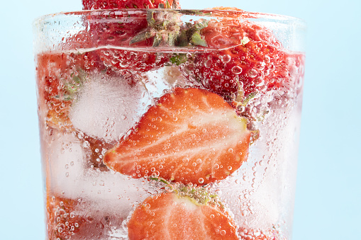 A closeup shot of berries and ice in sparkling water