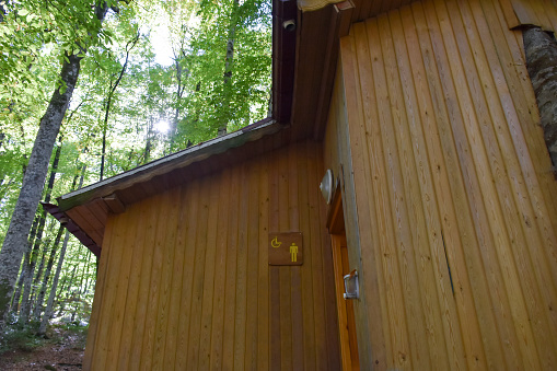 Public restroom, wooden facade public restroom in the forest
