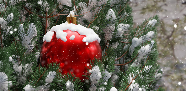 Christmas snow covered tree and red ball, close up. Winter season, cold and snow falling. Holiday greeting card. 3d render