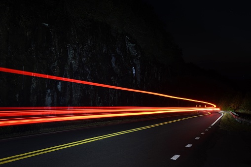 A long exposure shot of the light trails over the highway road at night