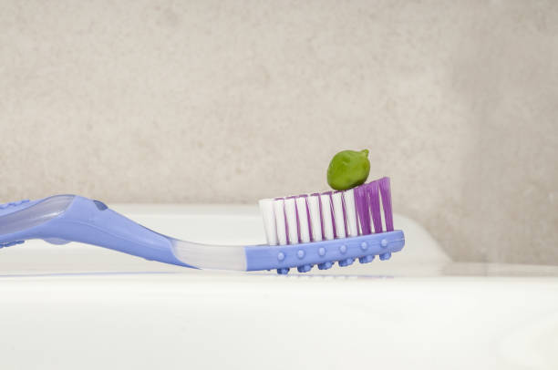 istock Selective focus shot of green toothpaste squeezed on the colorful toothbrush 1440544589