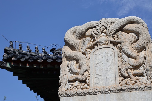 A closeup shot of white Traditional Chinese of stone tablet in Zhihua Temple, Beijing under blue sky