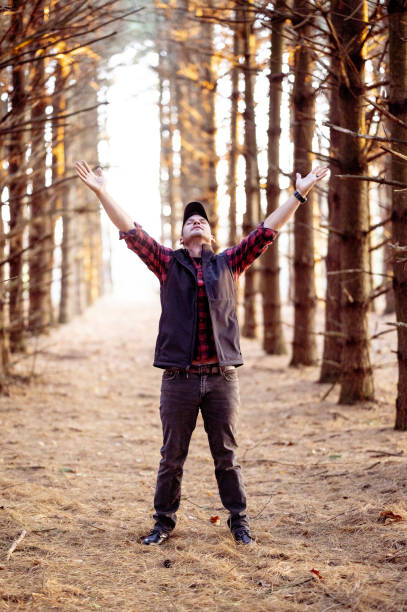 istock Vertical selective focus shot of a man praying in a forest 1440545590