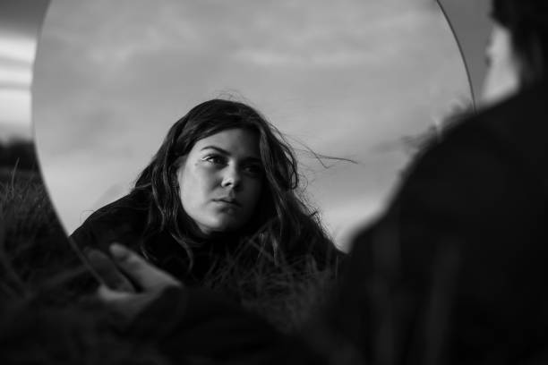 istock Young woman looking in the mirror self reflecting 1440546244