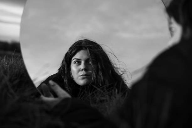 istock Young woman looking in the mirror self reflecting 1440546259