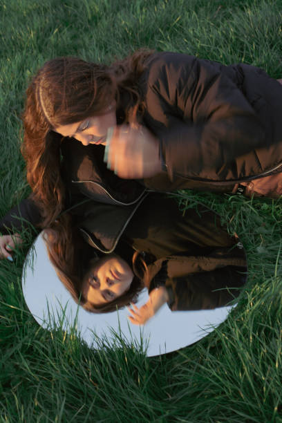 istock Young woman looking in the mirror self reflecting 1440546364