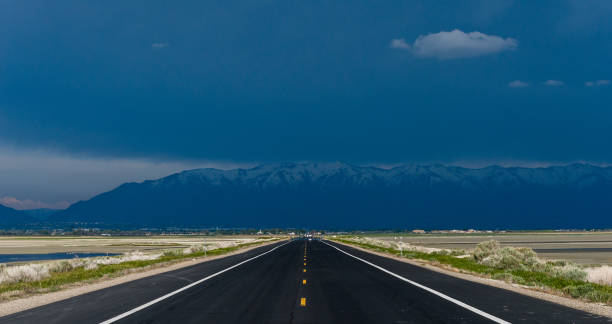 istock Mountains under heavy rain and a lonely road going towards them 1440546686
