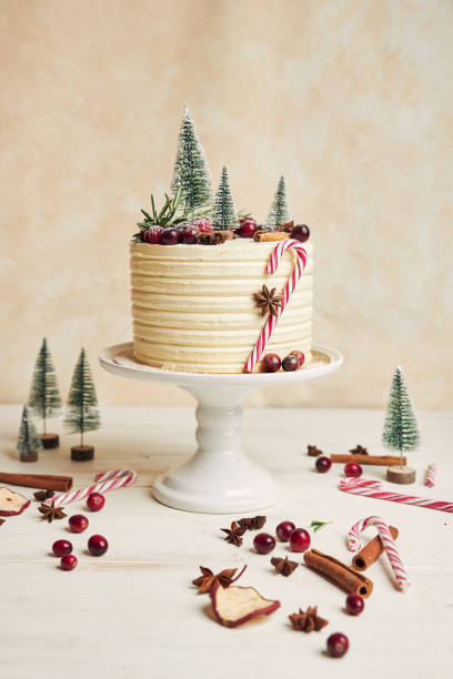 istock Vertical shot of a Christmas cake with beautiful decorations on a white table 1440547648