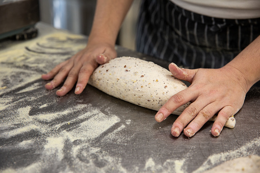 Stock photo showing a roti (also known as chapati) made from wholewheat atta flour being prepared with rolling pin by unrecognisable person. A roti is a traditional Indian flatbread often eaten with curries.