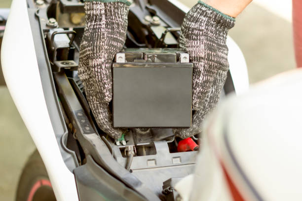 istock Auto mechanic replace motorcycle battery, Car maintenance service. 1440548943