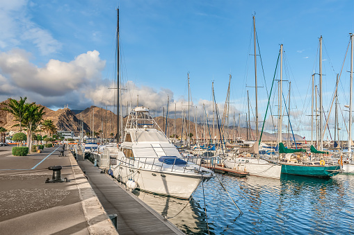 Beautiful seascape with yachts against the backdrop of mountains in the Port of Santa Cruz de Tenerife in the Canary Islands, Spain. Delightful landscape on the embankment of the Atlantic Ocean