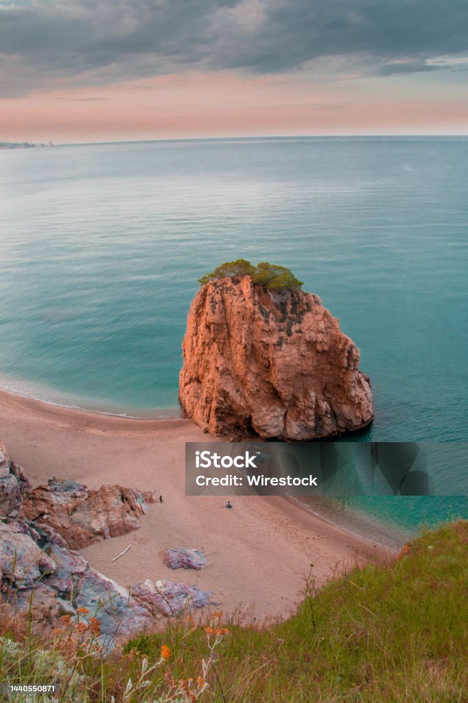 Vertical shot of a big rock by the ocean captured in Begur, Spain A vertical shot of a big rock by the ocean captured in Begur, Spain Andalusia Stock Photo