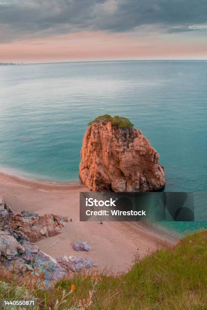Vertical Shot Of A Big Rock By The Ocean Captured In Begur Spain Stock Photo - Download Image Now