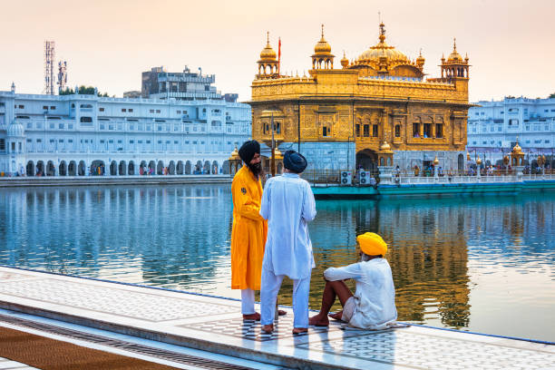 guarda sikh conversando com devotos no templo dourado sri harmandir sahib gurdwara em amritsar, punjab, índia. templo dourado é o gurdwara mais sagrado do siquismo - amristar - fotografias e filmes do acervo