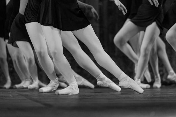 istock Grayscale closeup shot of ballet performers on stage 1440551749