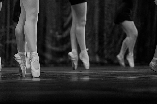 A grayscale closeup shot of ballet performers on stage