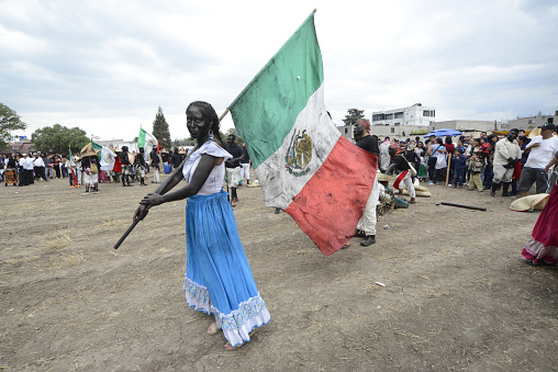 Chiautla, Mexico – December 06, 2020: Chiautla, State of Mexico, / Mexico; May 5, 2018, Woman carrying her flag at the 5 de Mayo festival in Mexico