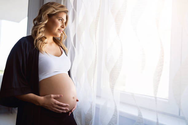 кавказская беременная женщина касается живота - human pregnancy rubbing looking down abdomen стоковые фото и изображения