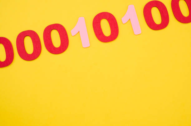 istock Top view of red and pink binary codes on a bright yellow surface 1440552643