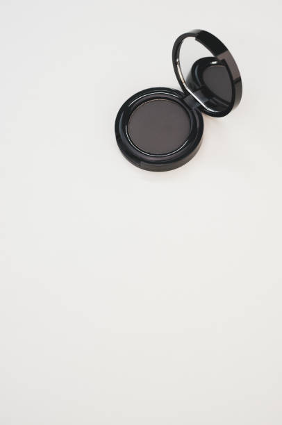 istock Vertical shot of a single black eyeshadow palette with a mirror on a surface 1440552644