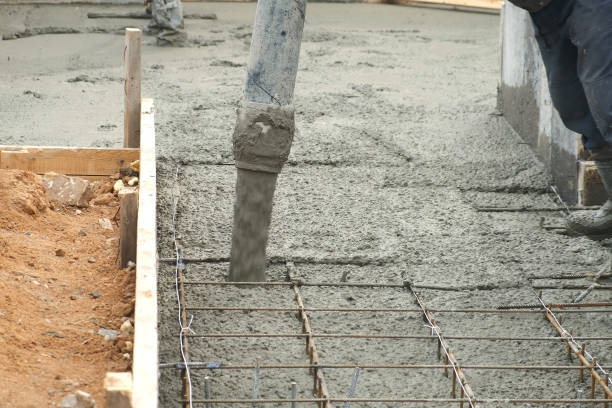 istock Man is pouring foundation with wet heavy concrete through pipe, closeup view. 1440552852