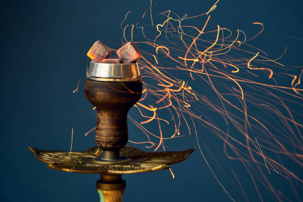 Burning coals in a bowl with hookah tobacco. Close-up, selective focus. stock photo