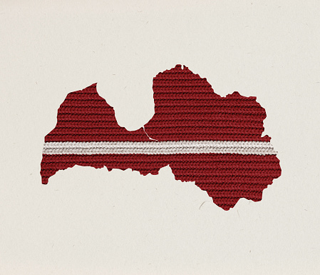 Creative conceptual design. Knitted texture of map of Latvia over grey background. Current problems of gas importration. Concept of political support, creativity, social protection