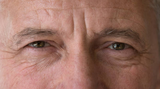 istock Mature man staring at camera, close up upper face view 1440554613