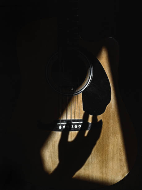 istock Closeup of a hand shadow strumming on guitar strings 1440555982