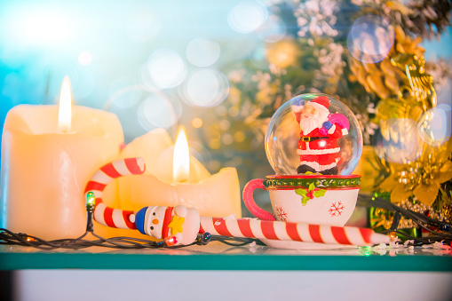 Christmas elf on a wooden bench and red lantern on background