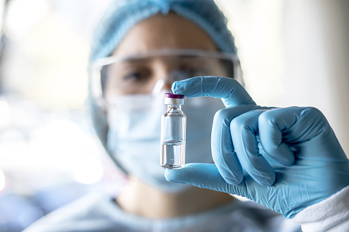 Medical doctor or laborant holding tube with nCoV Coronavirus vaccine for 2019-nCoV virus