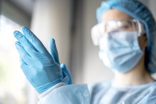 istock Female doctor putting on protective blue gloves 1440556679