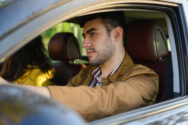 istock Young bearded Hispanic man driving a car with his girlfriend 1440556718