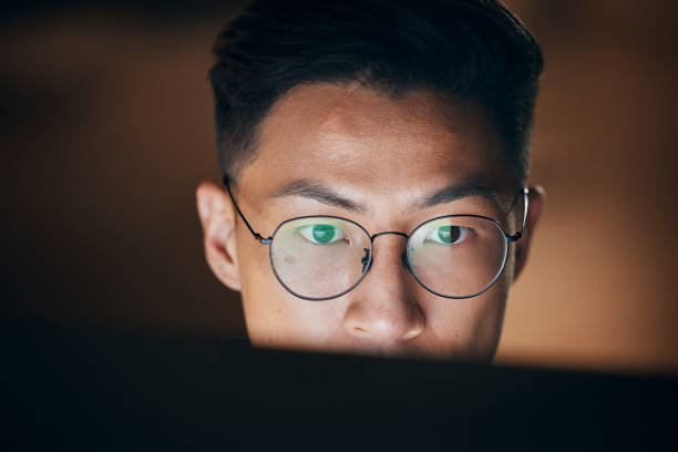 istock Night business, asian man and computer desktop planning, technology and analytics, online research and strategy in digital marketing agency. Focus Japanese employee face working on pc in dark office 1440556723