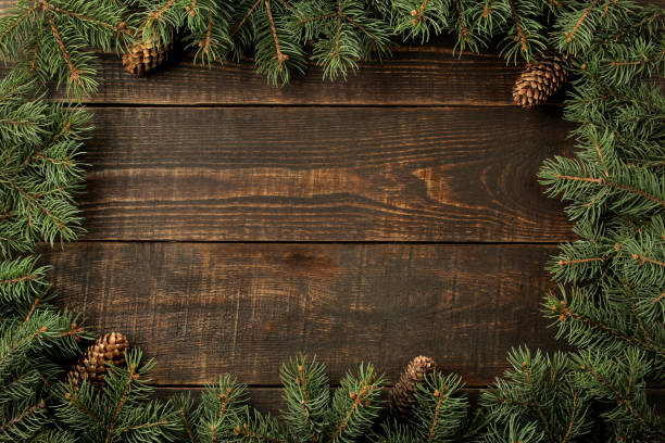 istock Christmas and New Year frame for text with Christmas tree and pine cones on brown background. view from above. 1440556846