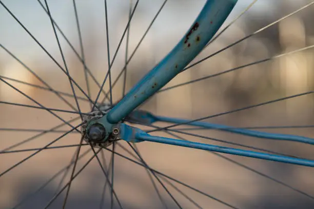 A selective focus shot of the wheel of a vintage bicycle