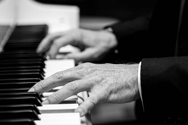 istock Grayscale shot of old hands playing the piano 1440559917