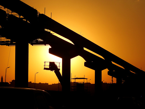 Cairo, Egypt, October 21 2022: A Silhouette of a construction site of Cairo Monorail which is a two-line monorail over road rapid transit system currently under construction, elevated rail transport, selective focus