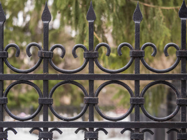 istock Forged fence with artifacts on bokeh green backround. 1440566472