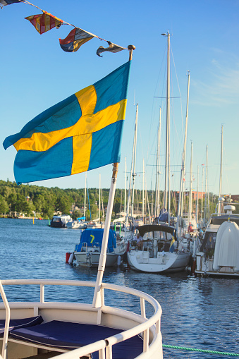 Swedish flag at the back of a boat in the harbor of Motala in Östergötland, Sweden.