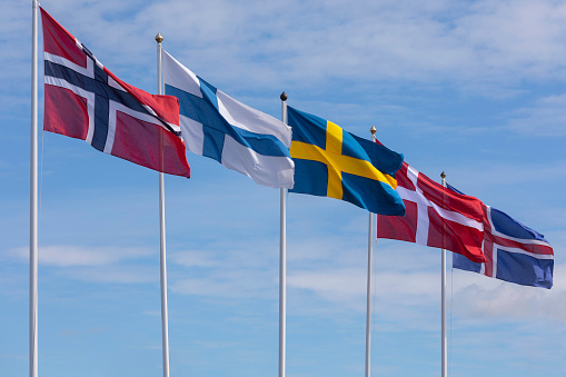 Flags of the nordic countries of Europe in a row - the norwegian, finnish, swedish, danish and icelandic flags.
